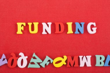 Renkli abc alfabe blok ahşap gelen mektuplar oluşan kırmızı bir arka plan üzerinde kelime finansman, reklam metin için yer kopyalayın. Öğrenme İngilizce kavramı
