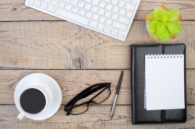 Bilgisayarlı ahşap ofis masası, kalem ve bir fincan kahve, bir sürü şey. Kopyalama alanı olan üst görünüm