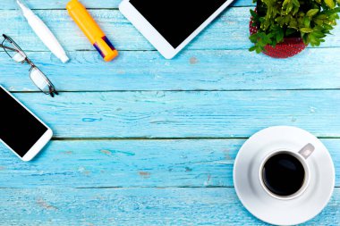 Bilgisayarlı mavi ofis masası, kalem ve bir fincan kahve, bir sürü şey. Kopyalama alanı olan üst görünüm