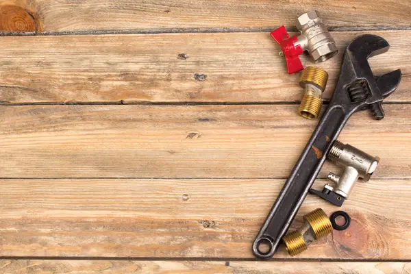 Teçhizatlar, boru, valfler, su için plastik boru ahşap arka planda ayarlanabilir ingiliz anahtarı. Üst Manzara. Metin için alanı kopyala