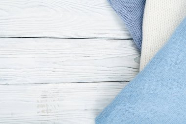 Örgü yün kazaklar. Ahşap arka planda örülmüş kış kıyafetleri, kazaklar, örgü giysileri, metin için yer.