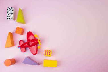 Masadaki renkli ahşap tuğlaların üst görüntüsü. Erken öğrenme. Pembe arka planda eğitici oyuncaklar. Çocuğun gelişimi için..