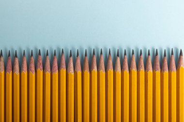 Açık mavi arkaplanda bir sıra sarı kalem..