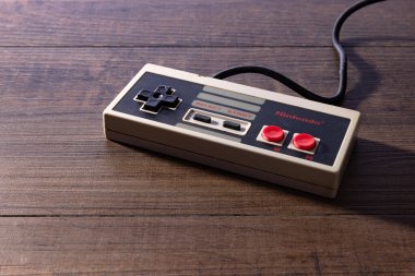 Springfield, MO ABD - 26 Temmuz 2025: Nintendo Eğlence Sistemi denetleyicisi eski ahşap arka planda.