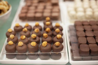 Şenlikli beyaz masada siyah ve kahverengi çikolatadan yapılmış lezzetli tatlılar ve kurabiyeler.