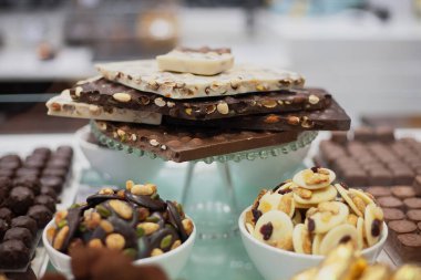 Şenlikli beyaz masada siyah ve kahverengi çikolatadan yapılmış lezzetli tatlılar ve kurabiyeler.