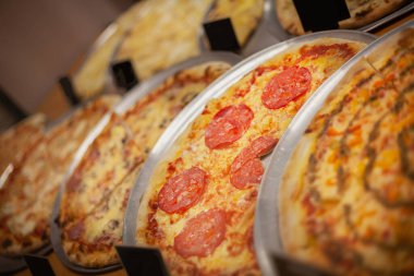 Different types of delicious pizza on a plate with tomatoes and cheese