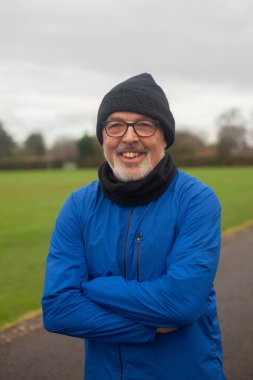 Yaşlı bir adam spor için içeri girer, dışarıda spor kıyafetleriyle temiz havada koşar.