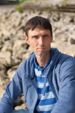 Neşeli, orta yaşlı, neşeli bir adam. Dışarıda güneşli bir günde.