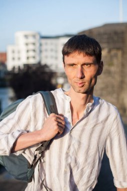 Neşeli, orta yaşlı, neşeli bir adam. Dışarıda güneşli bir günde.