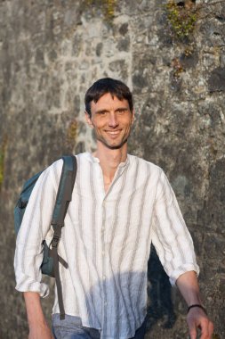 Neşeli, orta yaşlı, neşeli bir adam. Dışarıda güneşli bir günde.