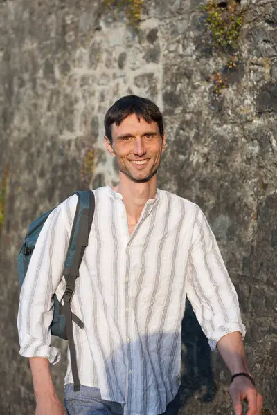 Neşeli, orta yaşlı, neşeli bir adam. Dışarıda güneşli bir günde.