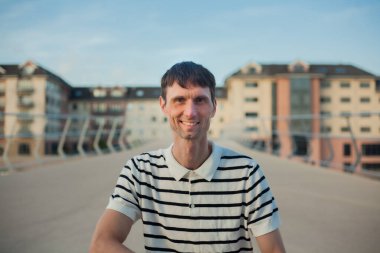 Neşeli, orta yaşlı, neşeli bir adam. Dışarıda güneşli bir günde.