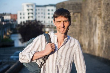 Neşeli, orta yaşlı, neşeli bir adam. Dışarıda güneşli bir günde.