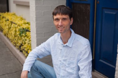 Neşeli, orta yaşlı, neşeli bir adam. Dışarıda güneşli bir günde.