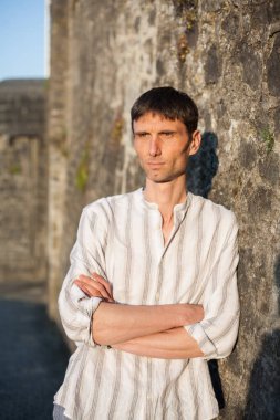 Neşeli, orta yaşlı, neşeli bir adam. Dışarıda güneşli bir günde.