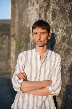 Neşeli, orta yaşlı, neşeli bir adam. Dışarıda güneşli bir günde.