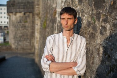 Neşeli, orta yaşlı, neşeli bir adam. Dışarıda güneşli bir günde.