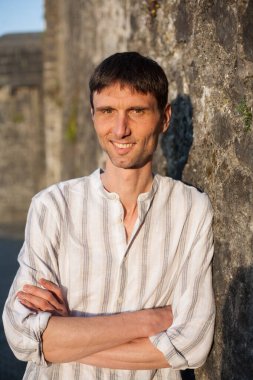 Neşeli, orta yaşlı, neşeli bir adam. Dışarıda güneşli bir günde.