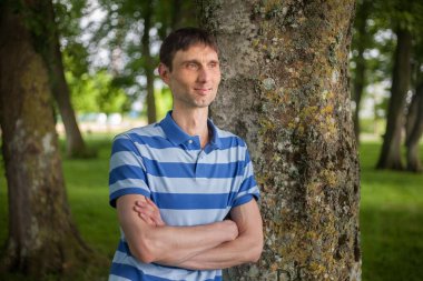 Neşeli, orta yaşlı, neşeli bir adam. Dışarıda güneşli bir günde.