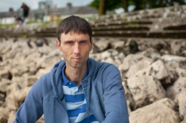 Neşeli, orta yaşlı, neşeli bir adam. Dışarıda güneşli bir günde.