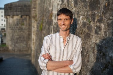 Neşeli, orta yaşlı, neşeli bir adam. Dışarıda güneşli bir günde.