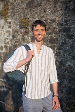 Neşeli, orta yaşlı, neşeli bir adam. Dışarıda güneşli bir günde.