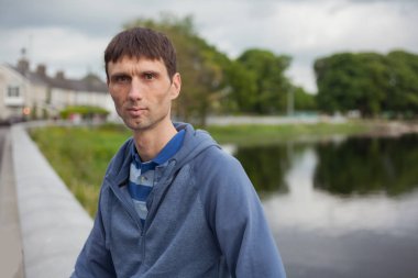 Neşeli, orta yaşlı, neşeli bir adam. Dışarıda güneşli bir günde.