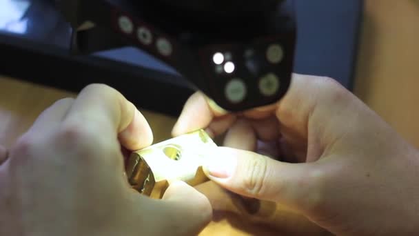 一位专家的手握住金属锁 用显微镜检查 — 图库视频影像