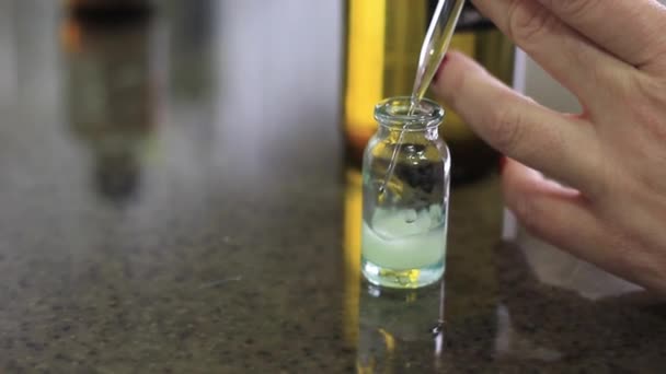 女性の手は 化学溶液を混合するためのフラスコに液体を注ぎます — ストック動画
