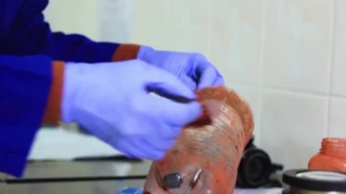 Uzman, çalışma nesnesini izleri tanımlamak için manyetik tozla lekeler.