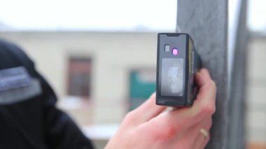 Lazer mesafe bulucu kullanan erkeklerin elleri bir nesnenin uzunluğunu ölçer.