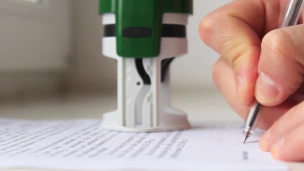 人的手用钢笔在文件上签名 并加盖邮票 — 图库视频影像