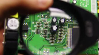 Microchippanel, the board is viewed under a magnifying glass.