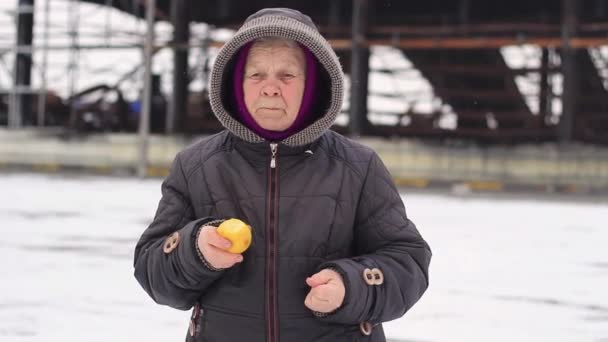 老妇人 在废墟的后面吃着一个苹果 — 图库视频影像
