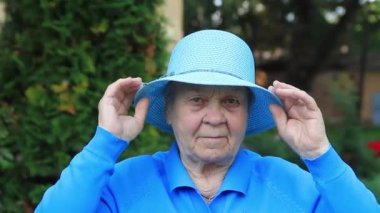 Yaşlı bir kadın, bir büyükanne, mavi bir şapka takıyor..
