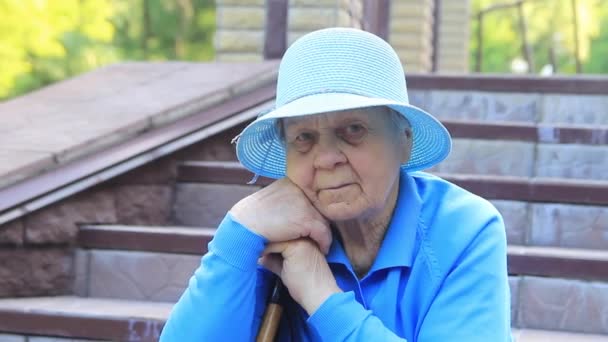 Elderly Woman Grandmother Sitting Wearing Hat Holding Stick — Stock Video