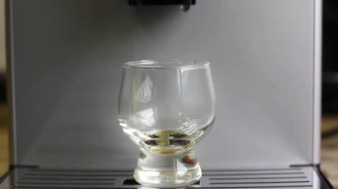 Kahve makinesi bardağa kahve doldurur..