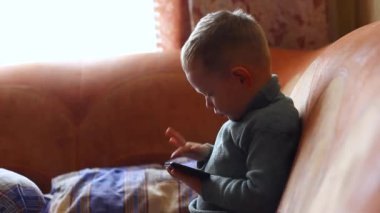 Küçük çocuk, çocuk cep telefonuyla oynuyor, telefon evde kapalı..