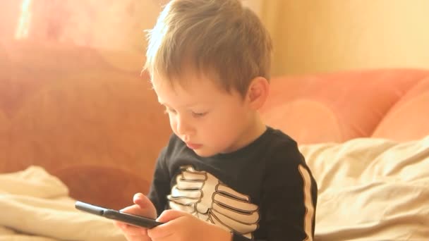 Menino Brincando Telefone Enquanto Sentado Sofá — Vídeo de Stock