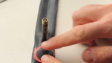 Adamın biri bisiklet tüpüne bir yama yapıştırıyor..