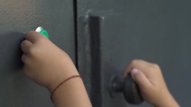Bir çocuğun eli elektronik bir dahili telefon anahtarı kullanarak kapıyı açar..