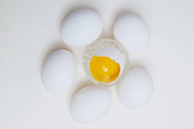 Beyaz arka planda yumurta sarısı ve yumurta sarısı var..