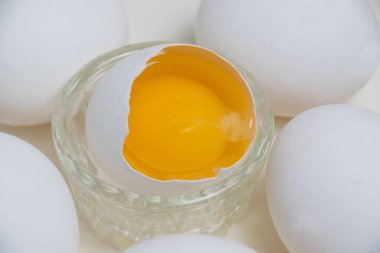 Beyaz bir arka planda kabukta bir sürü yumurta sarısı ve makro yumurta..