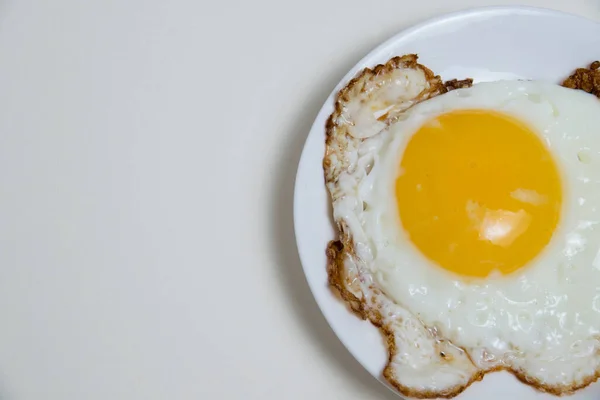 Fried egg on white plate and boiled egg in shell isolate on white background with space for text. Concept of high prices for eggs and food. Concept of healthy eating.