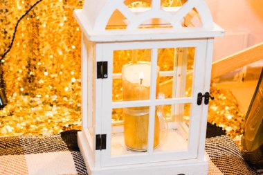 Güzel beyaz mum, Noel süsü ve arka planda parlak bir çelenk..