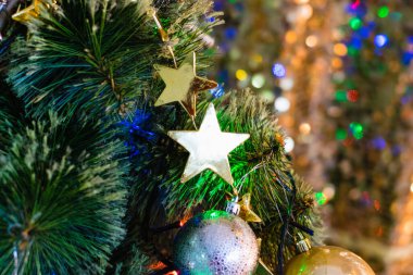 Noel ağacında güzel bir Noel yıldızı süsü ve arka planda parlak bir çelenk. Dünyada Noel kutlaması kavramı.