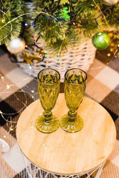 stock image Glasses of sparkling champagne near the Christmas tree, garland and Christmas decoration. Christmas and New Year celebrations