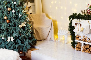 New Years photo zone in the studio with a Christmas tree, an armchair and a decorative fireplace.