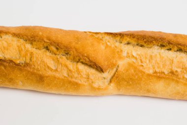 French baguette on a white background with copy space. Delicious appetizing crust of a bun close-up.